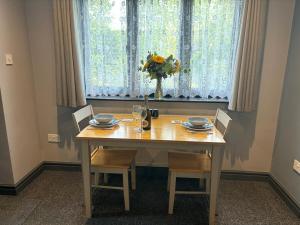 a dining room table with chairs and a vase of flowers at Snipeview in Hagwothingham