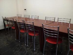 a conference room with a wooden table and chairs at Hotel Meridian With Car Parking in Shimla