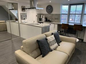 a living room with a couch and a kitchen at Stonehaven Centre - Carron Apartment in Stonehaven