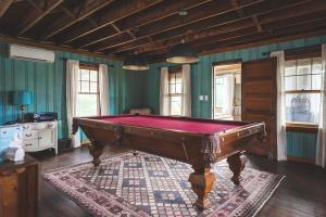 a pool table in a room with green walls at Stay at Little River in Gloucester