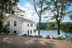 a white house next to a body of water at Stay at Little River in Gloucester