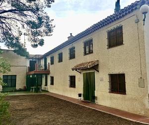 a large white building with a green door at Casica de Hellín in Hellín