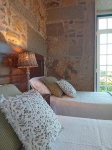 two beds in a room with a stone wall at Casa Pita Caminha in Caminha +88 photos