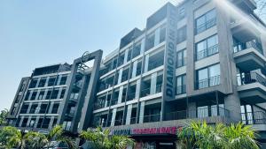 a large building with trees in front of it at Elite Luxury Suites at The Diamond in City in Cantonments