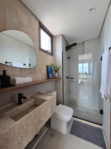 a bathroom with a sink and a toilet and a mirror at Perto do mar Self check in Infraestrutura completa in Salvador