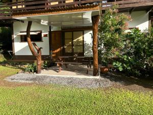 a house with a bench in front of it at Ana Lodge Tepua in Uturoa