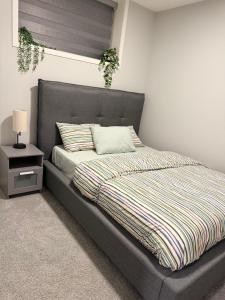 a bedroom with a bed and a nightstand with a bed sidx sidx at Relax, Recharge, Repeat 2Bedroom Walkout Haven in Calgary