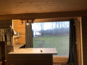 a kitchen with a large window in a log cabin at Saare-Toominga camping house in Väike-Rakke