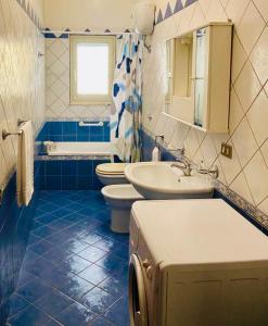 a blue and white bathroom with two toilets and a sink at La sKALunATa-Borgo di Kalat-Affitti brevi per uso turistico in Siculiana