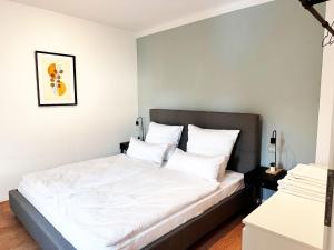 une chambre avec un lit avec des draps blancs et des oreillers dans l'établissement 60qm Apartment mit 2 Betten in Viersen - Central - High ceiling, à Viersen