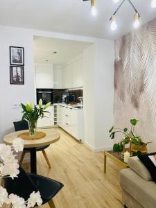 a living room with a table and a kitchen at Apartament lovely space in Rzeszów