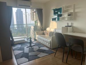 a living room with a couch and a table and a window at LPN Premium Apartment Pattaya in Pattaya North