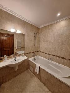a bathroom with two sinks and a tub and a mirror at St Ivan Rilski Private Apartment - 4 stars SPA - Slopes View in Bansko