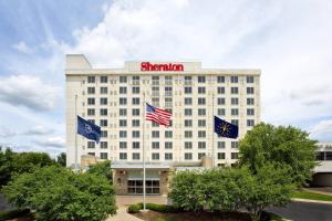 un hotel con dos banderas delante en Sheraton Louisville Riverside Hotel, en Jeffersonville