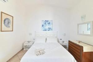 - une chambre blanche avec un grand lit et une commode dans l'établissement Sea View Apartment 90 m² in South Sardinia, à Villasimius