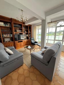 a living room with a couch and a chair at Piso frente al mar Casa Ruchelo in Camelle