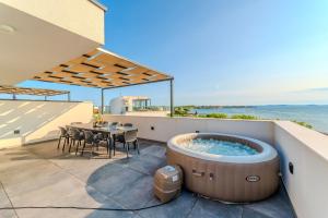 a hot tub on the roof of a house at Beachfront Villa Jugo with Seaview in Privlaka