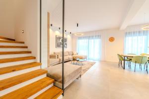 a living room with stairs and a dining room at Beachfront Villa Jugo with Seaview in Privlaka