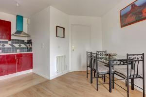 eine Küche und ein Esszimmer mit Tisch und Stühlen in der Unterkunft Le Sully - Mantes la jolie in Mantes-la-Jolie