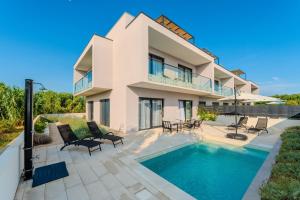 a villa with a swimming pool and a house at Beachfront Villa Jugo with Seaview in Privlaka