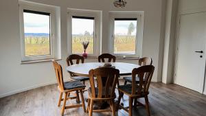 Un comedor con mesa y sillas y ventanas. en Ferienhaus Zum Brand, en Bütgenbach 22 fotos más