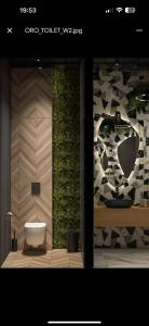 a bathroom with a toilet and a wall with plants at Pana Green Residence in Panagyurishte
