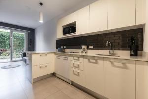 eine Küche mit weißen Schränken und einem Fenster in der Unterkunft Urban Flats Studios by Corporate Stays in San José