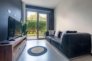 a living room with a black couch and a flat screen tv at Urban Flats Studios by Corporate Stays in San José