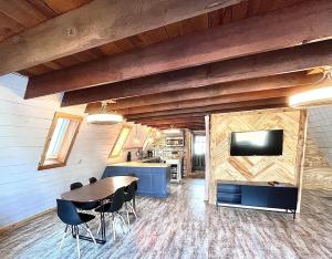 a dining room with a table and a tv on a wall at LakeFire Cabin in Eufaula