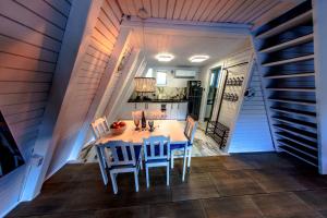 a kitchen and dining room with a table and chairs at Białe Molo - Domki & SPA in Międzybrodzie Bialskie