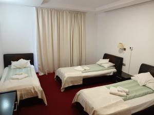 a hotel room with two beds with towels on them at Hotel Transilvania Zalău in Zalău +27 photos