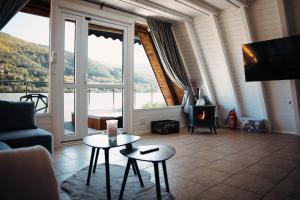 a living room with a fireplace and a large window at Białe Molo - Domki & SPA in Międzybrodzie Bialskie