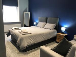 a bedroom with a large bed and a chair at Affordable Luxury 1 Stunning apartment Sunderland close to City centre hospital Crown Works Studio and Nissan in Sunderland