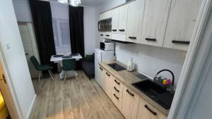 a kitchen with wooden cabinets and a table with a table at Salin Gold Ap in Turda