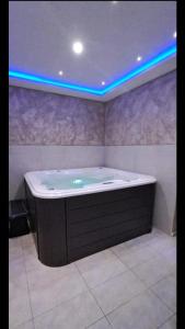a large bath tub with blue lights in a bathroom at VILA KATALINA 1 APARTMAN MAKRIC in Zlatibor