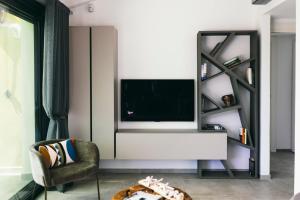 a living room with a tv and a chair at BLUVARI' Charming House in Alassio