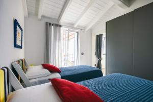 a bedroom with two beds with red and blue at BLUVARI' Charming House in Alassio +58 photos