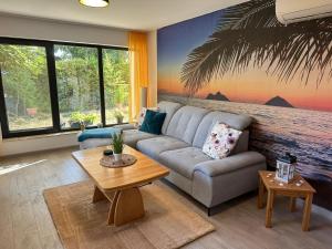 a living room with a couch and a palm tree mural at Villa Black Sea in Balchik