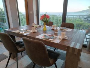 a dining room table with chairs and a large window at Villa Black Sea in Balchik