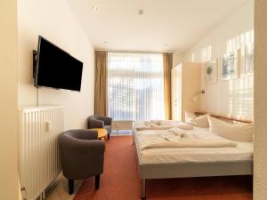 a hotel room with two beds and a flat screen tv at Elegant eingerichtete Ferienwohnung in Granzow