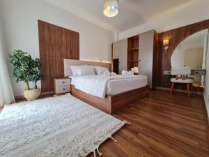 a bedroom with a large white bed and a mirror at Garden view apartment in Madinaty