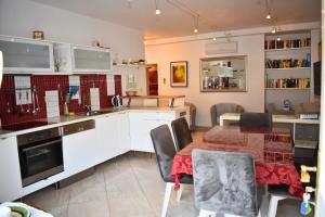 a kitchen with white cabinets and a table and chairs at Villa Columba - 4 Star Deluxe Apartments - Sea-Front & Panorama View in Makarska
