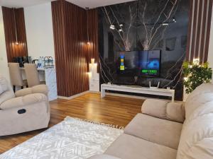 a living room with two white couches and a tv at Garden view apartment in Madinaty