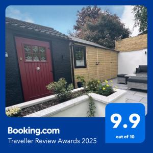 a house with a red door in a garden at Garden Lodge in Belfast
