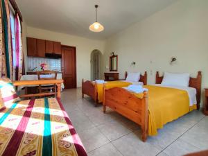 a bedroom with two beds and a table and chairs at Panorama in Amorgos