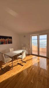 een eetkamer met een tafel en stoelen en het strand bij Panorama Apartment Marija in Stanići