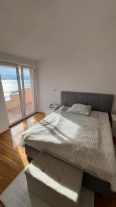 een slaapkamer met twee bedden en een groot raam bij Panorama Apartment Marija in Stanići +6 foto's