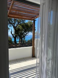 a room with a view of the ocean from a balcony at Golden olive villa in Lourdhata