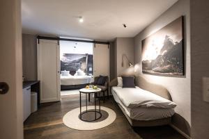 a small room with a bed and a table at Wellness Hotel Alpenhof in Zermatt +114 photos