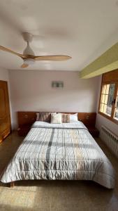a bedroom with a bed with a ceiling fan at Ca la Cabrera in Alfara de Carles